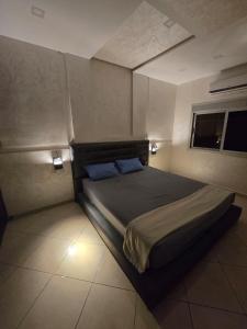 ein Schlafzimmer mit einem Bett mit zwei blauen Kissen in der Unterkunft MMA SAIDIA Resort in Saidia 