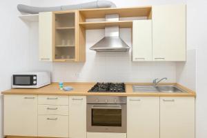 Una cocina con gabinetes blancos y un horno de estufa. en QUEEN HOME Sophia, en Bolonia