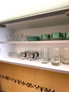 a shelf with plates and glasses on it at Apartman Bloom in Sarajevo +19 photos