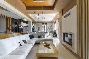a living room with a white couch and a fireplace at Villa Under Meteora in Kalabaka