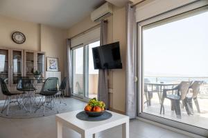 a living room with a television and a table with fruit at Eagles Nest Panoramic SeaView Apartment in Thérissos