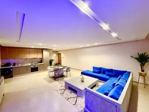 a living room with a blue couch and a table at Luxury Apartment with Pool & Parking in Tamraght 10 mn from Taghazout in Tamraght Ouzdar