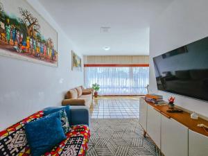 a living room with a couch and a flat screen tv at Beira Mar Ondina in Salvador