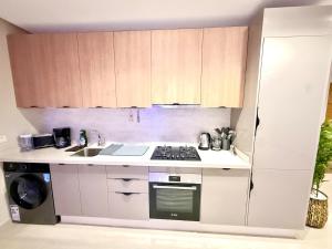 a small kitchen with a stove and a sink at Luxury Apartment with Pool & Parking in Tamraght 10 mn from Taghazout in Tamraght Ouzdar