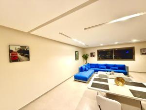 a living room with a blue couch and a table at Luxury Apartment with Pool & Parking in Tamraght 10 mn from Taghazout in Tamraght Ouzdar +21 photos