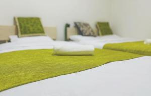 two beds with green blankets and pillows on them at Shinjuku新宿御苑 in Tokyo