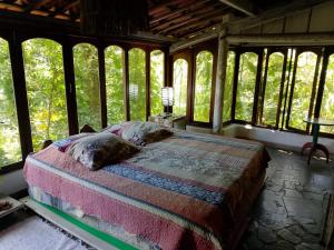 una camera da letto con un letto in una stanza con finestre di Cultura Mix Guest House a Arraial d'Ajuda