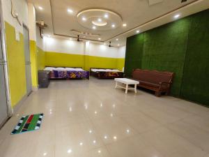 a room with two beds and a green wall at Hotel Janki Niwas - बाबा बैद्यनाथ मंदिर के निकट in Deoghar
