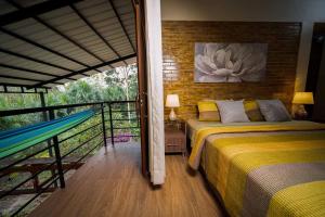 a bedroom with two beds and a hammock on a balcony at Puerto Bambú Nature and Relaxation in Moyobamba