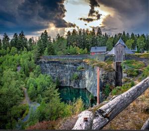 a house on a cliff next to a body of water at Ferienhaus Villa Zauberblick am Rennsteig Frankenwald in Ludwigsstadt