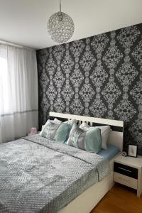 a bedroom with a bed with a patterned wall at Apartman Bloom in Sarajevo