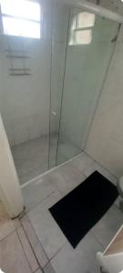 a shower with a glass door next to a toilet at Acomodação quarto compartilhado in Orleans