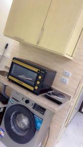 a tv sitting on top of a washing machine at living Hotel in 6th Of October