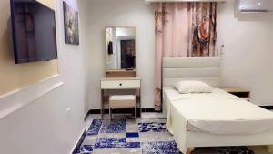 a small bedroom with a bed and a mirror at living Hotel in 6th Of October