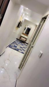 a hallway with white walls and a marble floor at living Hotel in 6th Of October