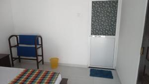 a small room with a refrigerator and a chair at Rooms in matara in Matara