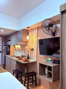 una cucina con televisore e bancone con sgabelli di Sunvida tower SM cebu a Cebu City