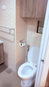 a bathroom with a white toilet in a room at Sunvida Tower Corner Suite Across SM Cebu in Cebu City