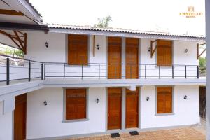 a building with wooden doors and a balcony at Castello Hotel in Polonnaruwa