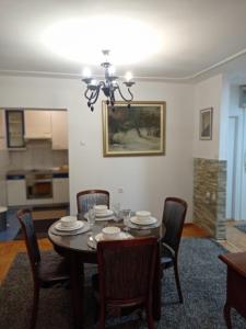 a dining room table with chairs and a chandelier at Central Residence Banja Luka Spacious Apartment with Private Parking in Banja Luka +17 photos