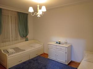 a bedroom with a bed and a chandelier at Central Residence Banja Luka Spacious Apartment with Private Parking in Banja Luka