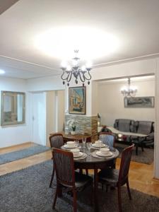 a dining room and living room with a table and chairs at Central Residence Banja Luka Spacious Apartment with Private Parking in Banja Luka