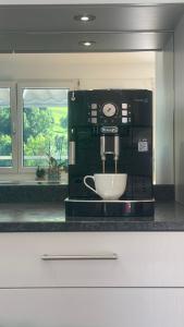 a kitchen with a coffee maker on a counter at Grosse Terrasse mit Privatsphäre & Aussendusche in Siebnen