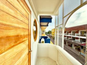 eine Tür zu einem Balkon mit Aussicht in der Unterkunft เมริโค่ บางแสน บีช Merico Bangsaen Beach in Ban Laem Thaen