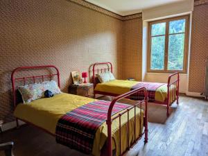 a bedroom with two beds and a window at La Maison de Marie in Les Rouges-Eaux