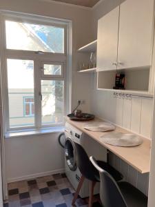 a kitchen with a washing machine and a window at Mo&Ko Kalamaja Apart - Self Check-in in Tallinn
