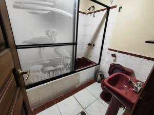 a bathroom with a red toilet and a sink at Hostería Tiopullo in Lasso +4 photos