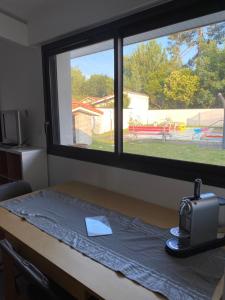 a room with a window and a table with a bag on it at Maison La Hume climatisée avec piscine et terrasse in Gujan-Mestras