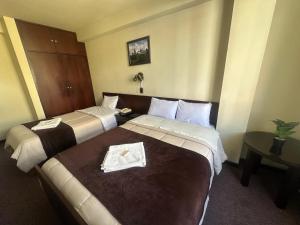 a hotel room with two beds and a table at Camino Real Puno in Puno +5 photos