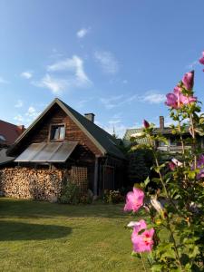 a house with a solar roof and pink flowers at Waszka in Białowieża