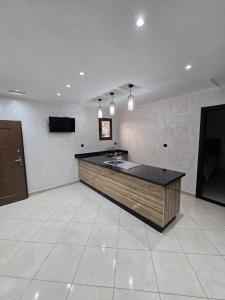 a large empty room with a counter and a television at Appartement ROOFTOP in Saidia 