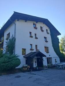a large white building with an umbrella in front of it at Pension Tyrol Maria Alm in Maria Alm am Steinernen Meer +13 photos