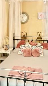 a bedroom with a bed with pillows and a clock on the wall at Holiday House Prodromos in Prodromos