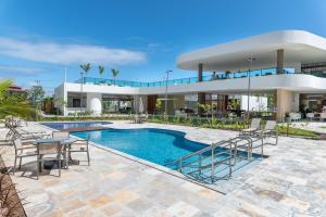 - un bâtiment avec une piscine et des chaises dans l'établissement Makia Beach Experience- Flat 202D, à Ipojuca