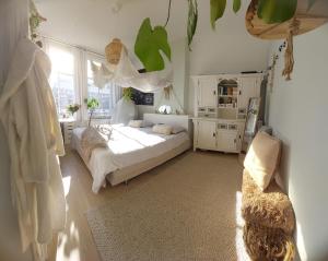 Una habitación blanca con una cama y una ventana en Historic townhouse 5 bedrooms, en Dordrecht