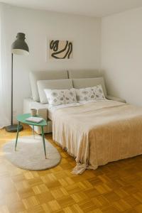 a bedroom with a bed and a green table at Bright furnished Studio with workspace and garden area near Zurich in Würenlos