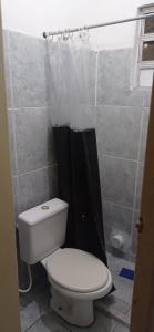a bathroom with a toilet and a black shower curtain at Residencial Barbosa - Apto 101 in Macaé