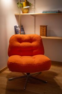 an orange chair sitting in a room at Cosy Studio on Wagner street, Riga Old Town in Rīga