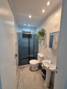 ein Badezimmer mit Toilette, Waschbecken und Dusche in der Unterkunft Apto 414- Prédio em frente da praia in Praia Grande