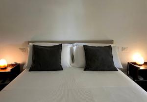 a bed with black and white pillows in a bedroom at Gate 10 - Bari Airport Apartment in Bari