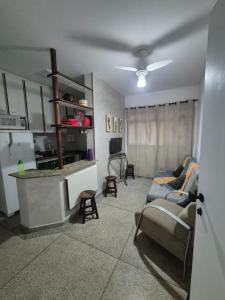 ein Wohnzimmer mit Couch und Küche in der Unterkunft Apto 414- Prédio em frente da praia in Praia Grande