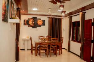 a dining room with a wooden table and chairs at Batti Lagoon Hotel in Batticaloa