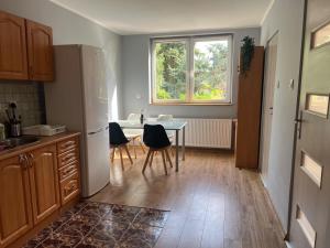 a kitchen with a table and a white refrigerator at Apartament Gajewniki in Gajewniki