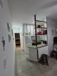 eine Küche mit einer Theke und einem Herd in einem Zimmer in der Unterkunft Apto 414- Prédio em frente da praia in Praia Grande + 2 Fotos