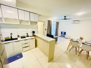 eine Küche mit weißen Schränken und einem Tisch und Stühlen in der Unterkunft Jim&Mie Cozy Homes 3R2BR at MIRAI Residence UKM GMI Kajang in Kajang
