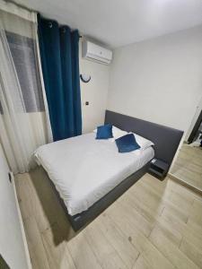 ein Schlafzimmer mit einem Bett mit blauen Kissen in der Unterkunft DELYA Maria in Abidjan